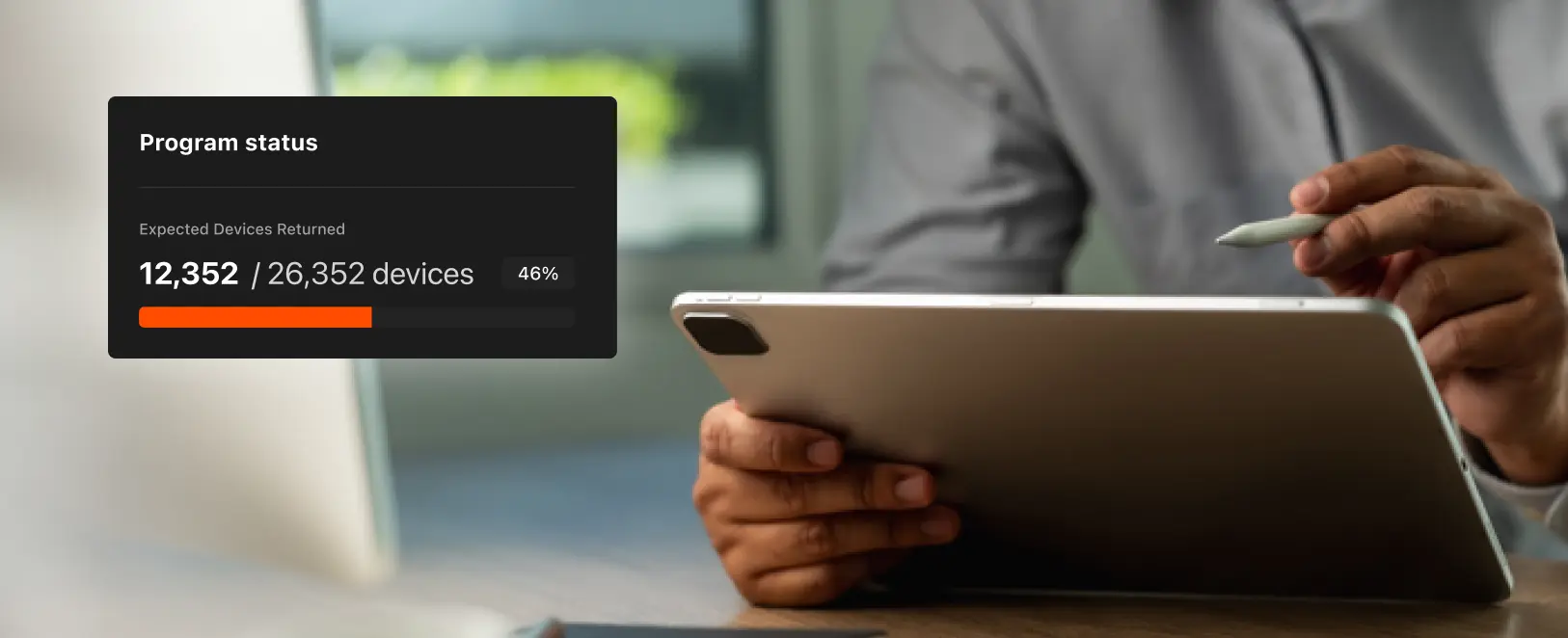 Hand holding a stylus pointing at a tablet screen with an overlay showing program status of 12,352 out of 26,352 devices returned, 46% completed with an orange progress bar.