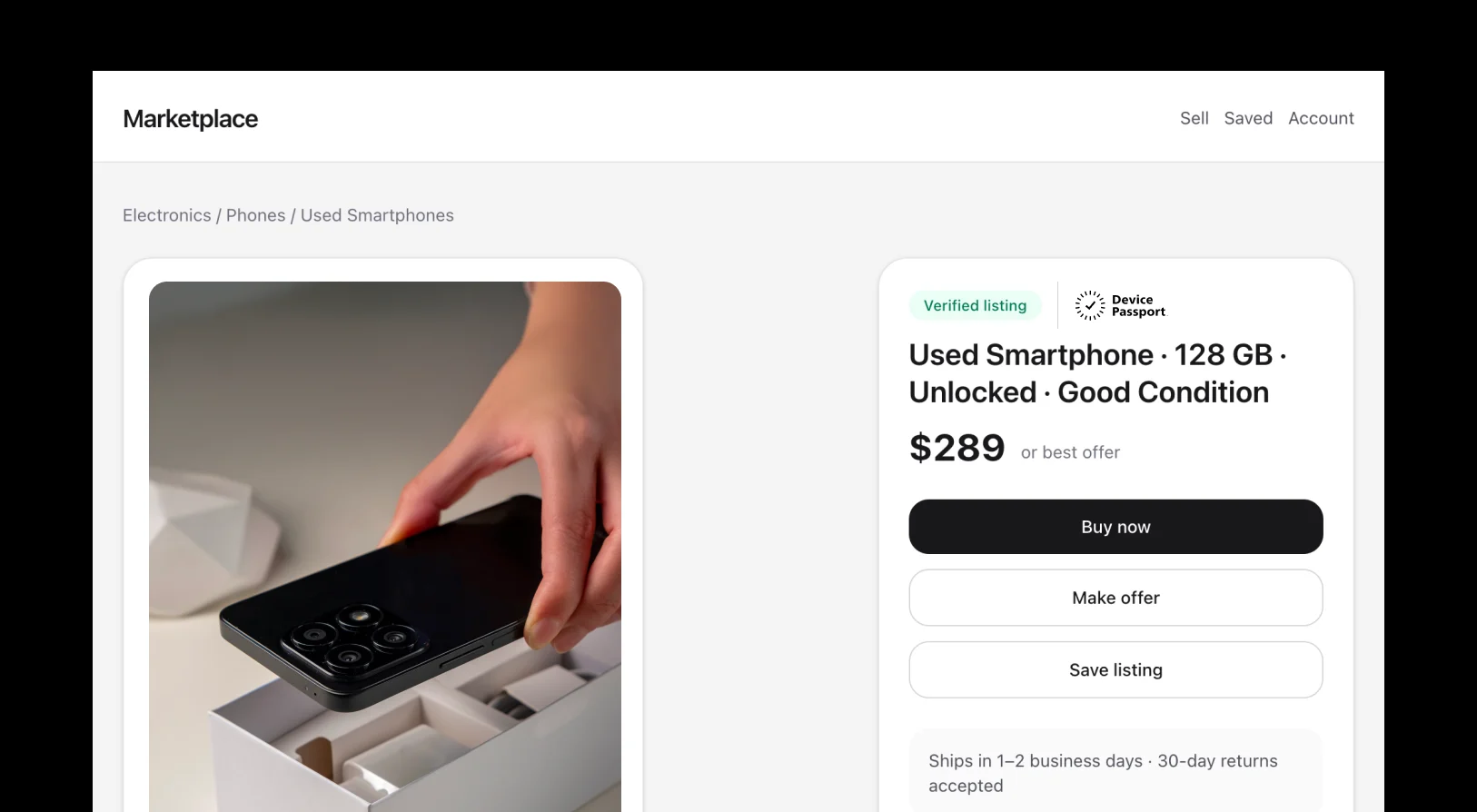 Hand holding a black smartphone above its white packaging box on an electronics marketplace listing page.