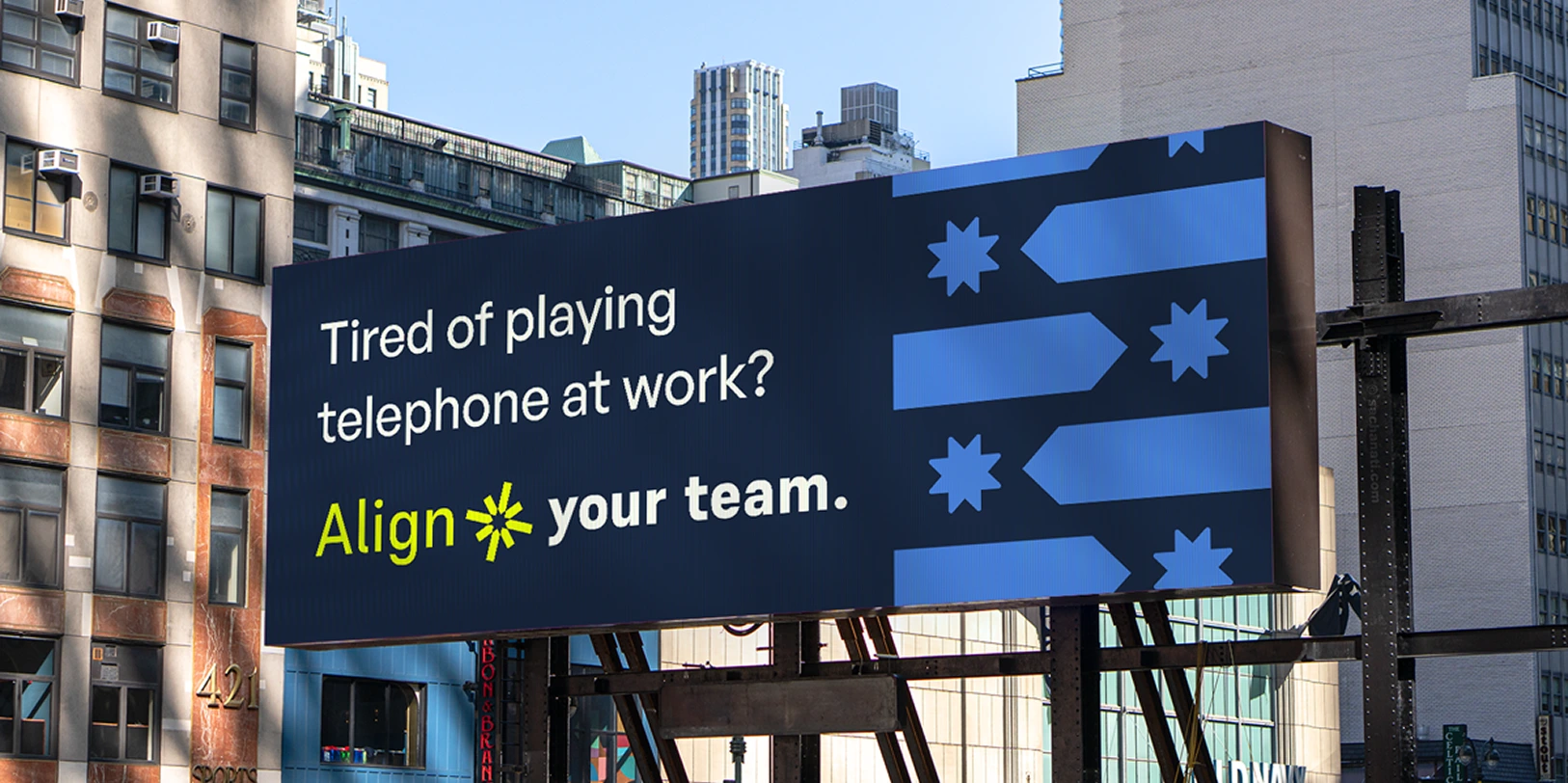 Billboard in a city reads: ‘Tired of playing telephone at work? Align your team.’ with blue arrows and a yellow starburst symbol.