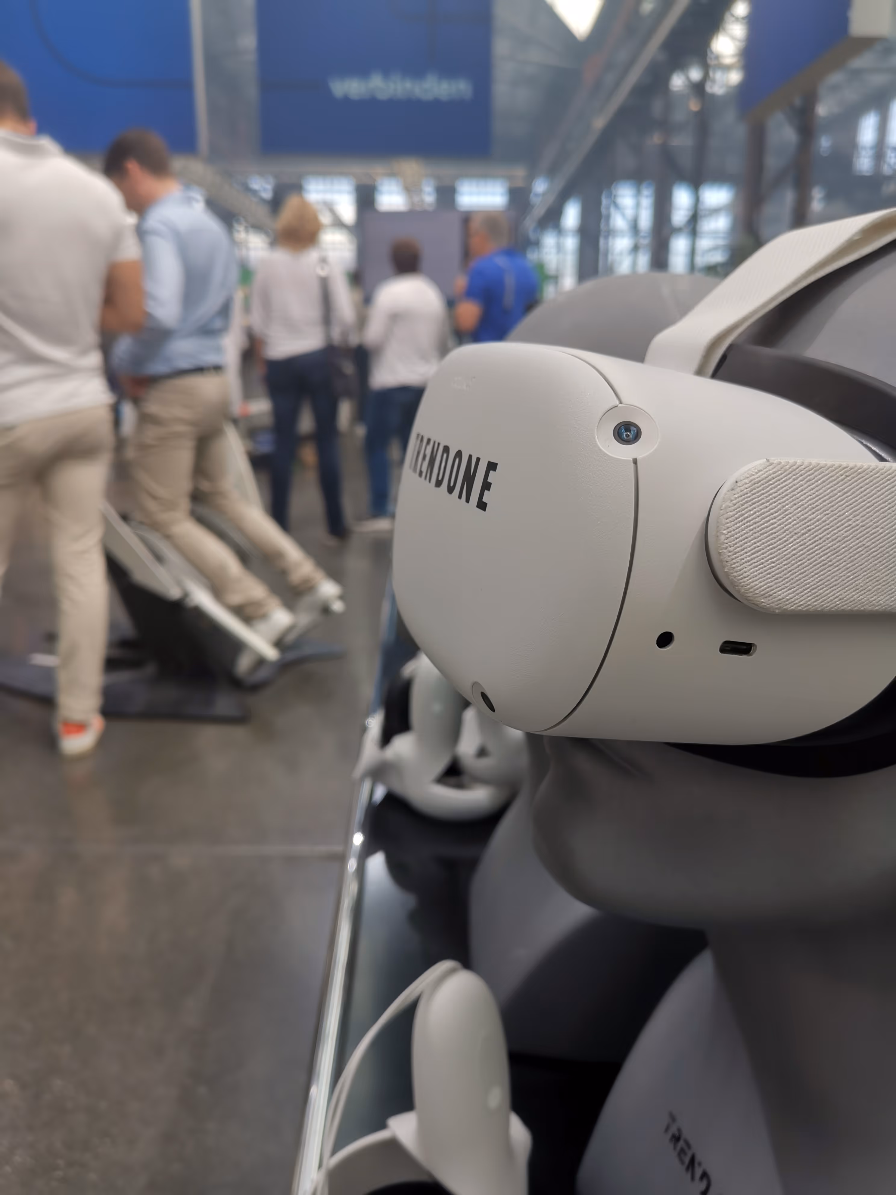 VR-Headset von Trendone an einer Schaufensterpuppe in Veranstaltungsort mit Menschen im Hintergrund.