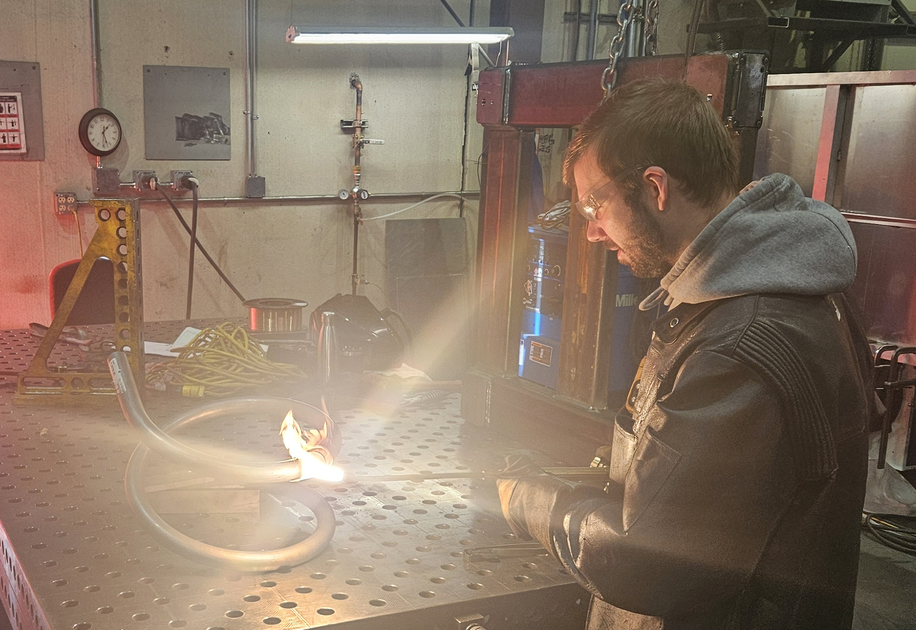 A man heats and shapes a piece of metal