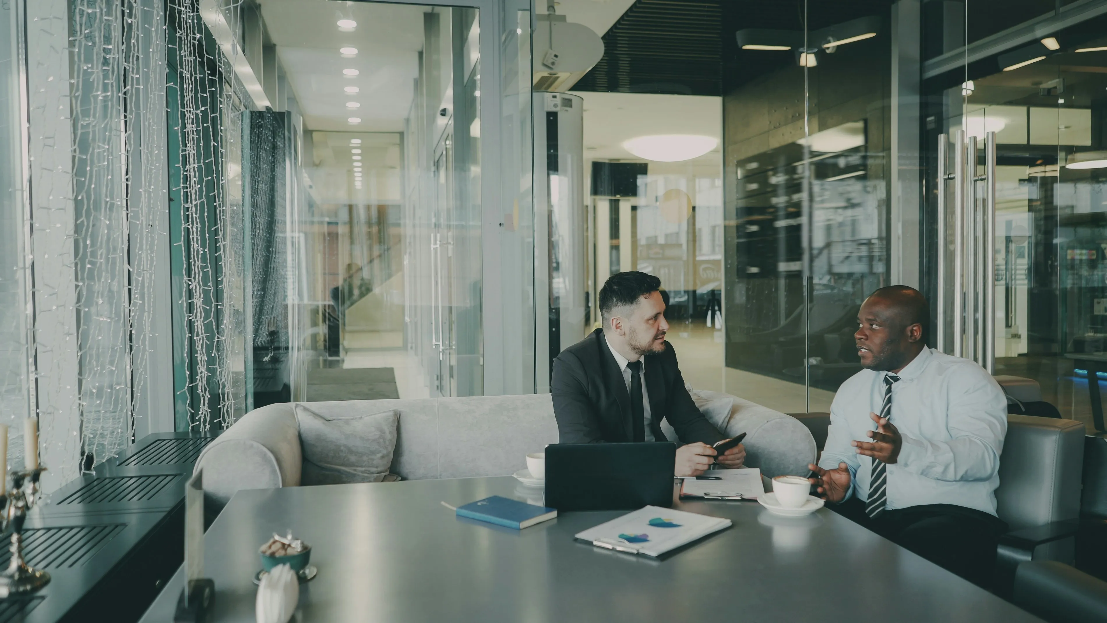 Two professionals in a business meeting reviewing documents — hotel acquisition fire safety due diligence discussion before handover