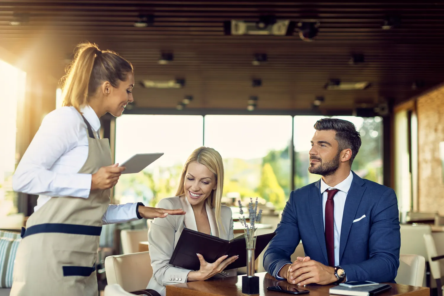 Hospitality staff serving guests in a restaurant — effective food safety training reflected in confident front-of-house competence
