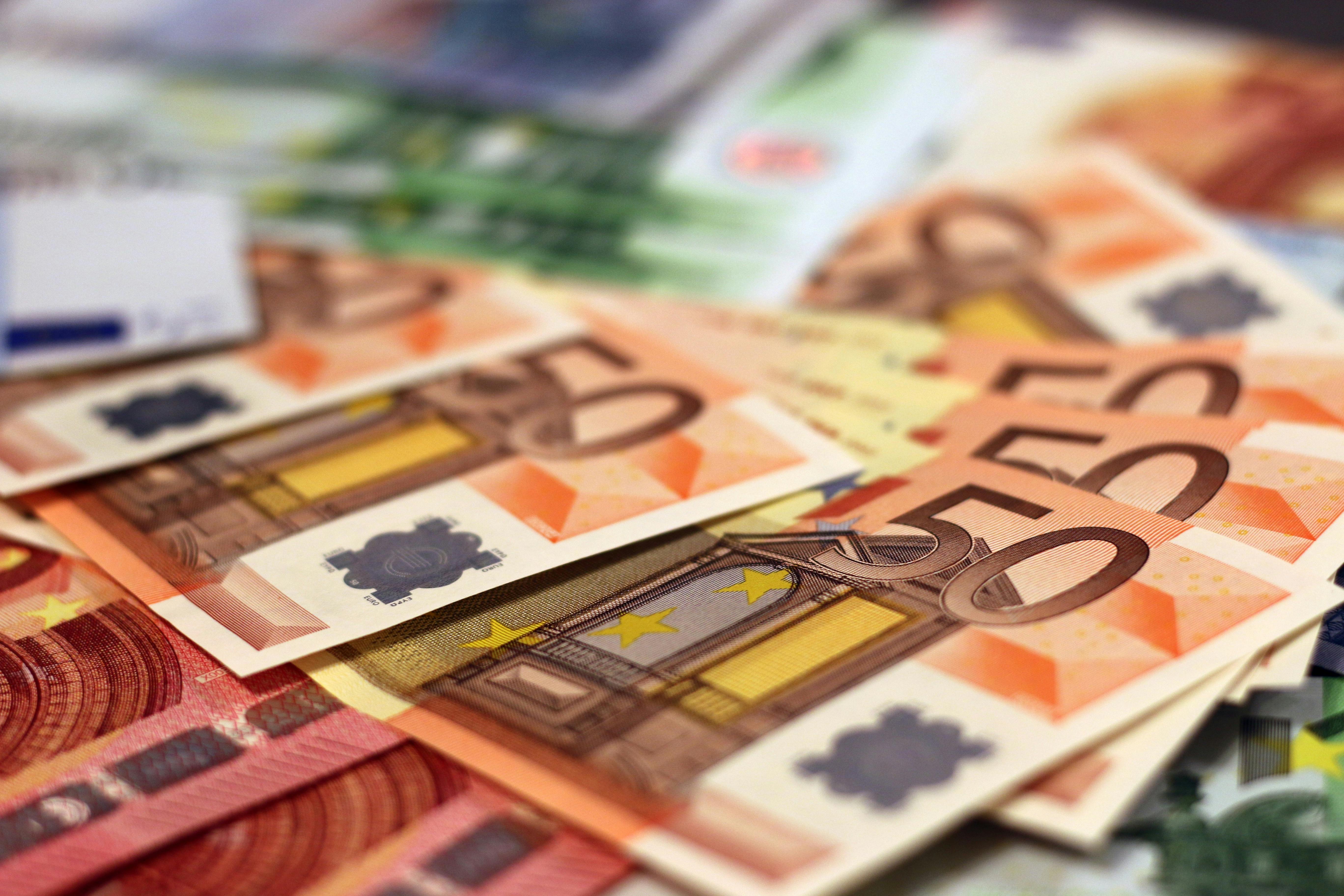 Close-up of multiple 50 euro banknotes fanned out in a pile.