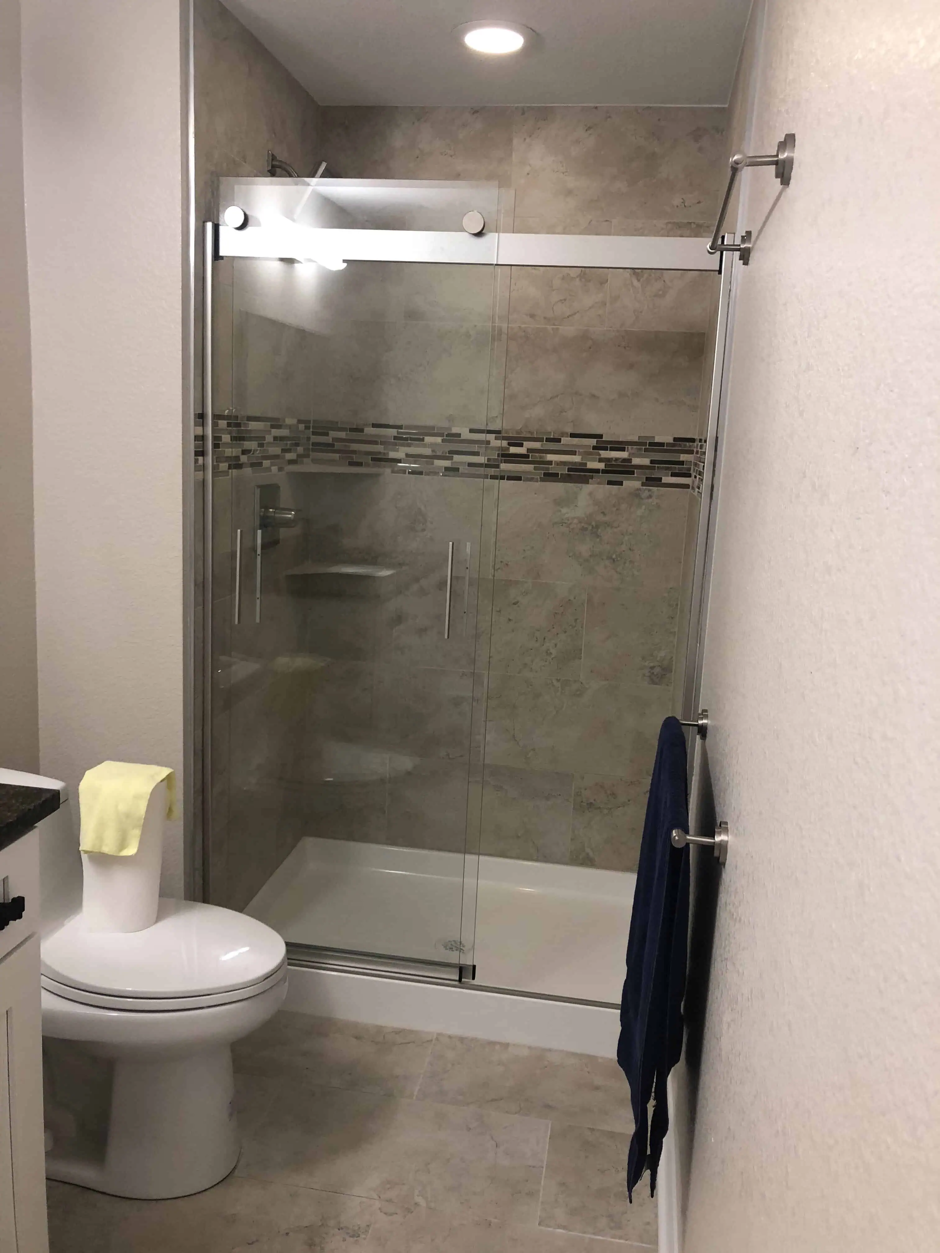 Modern bathroom remodeled by Blue Mountain Remodeling in Denver, featuring a glass-enclosed shower with tiled walls and a sleek toilet.