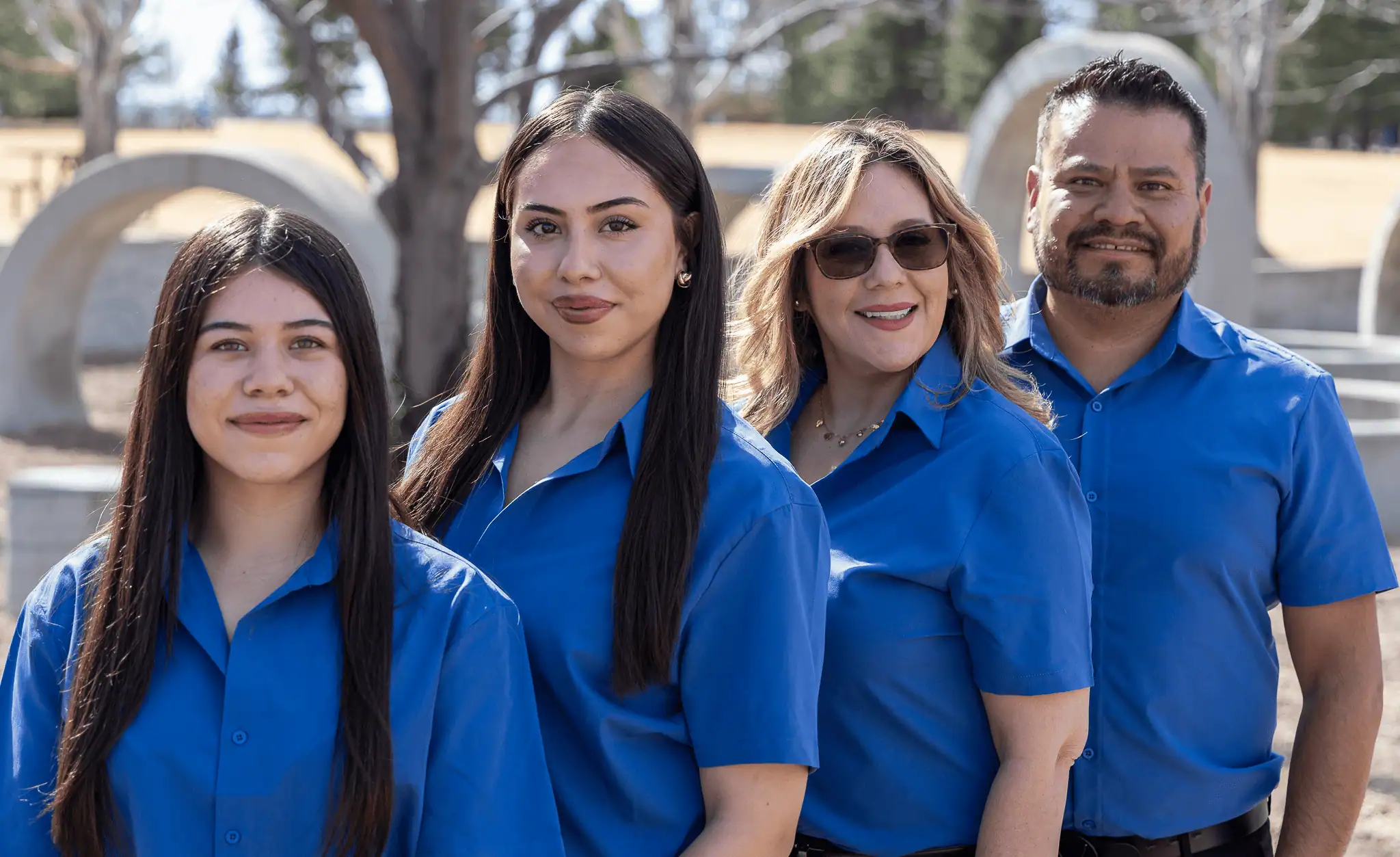 Team of professionals from Blue Mountain Remodeling smiling outdoors in matching blue shirts, representing Denver home renovation expertise.