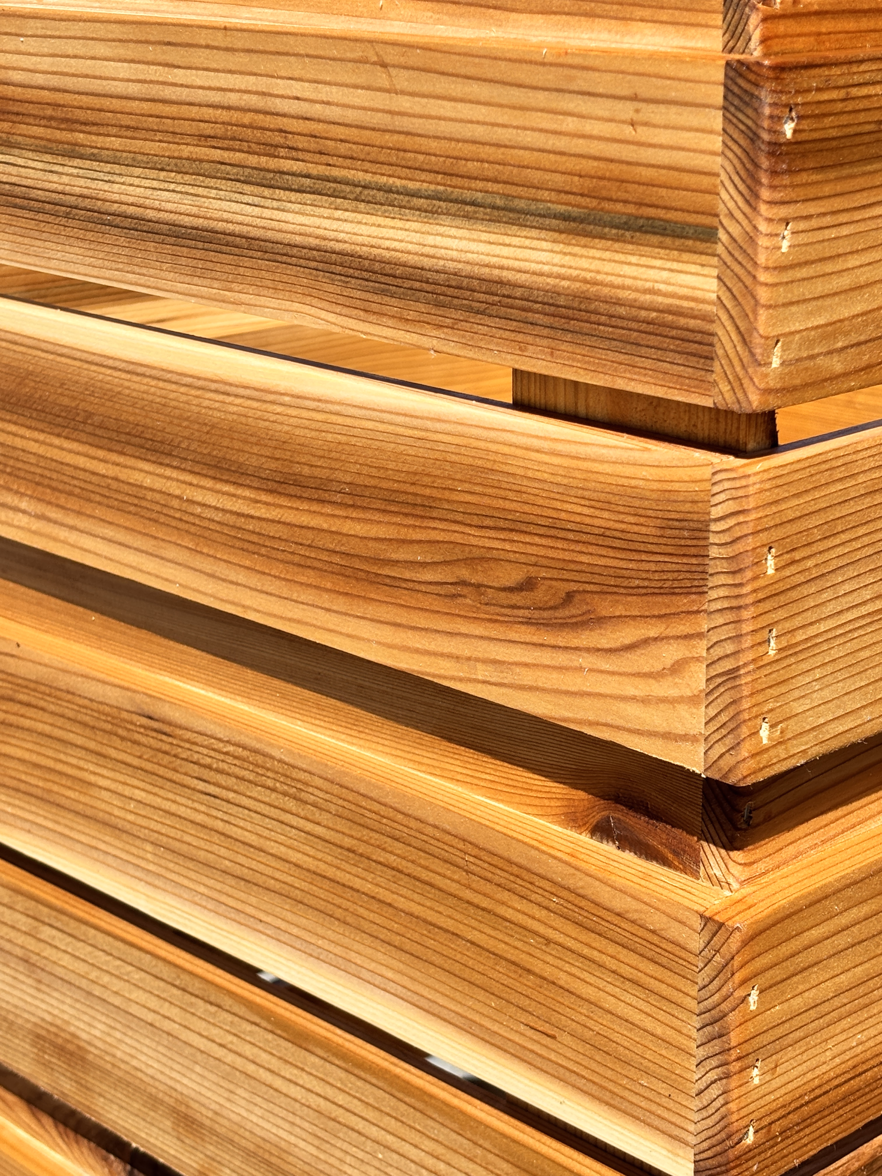 Close-up of well-crafted wooden corner joint featuring smooth, polished wood planks with visible grain.