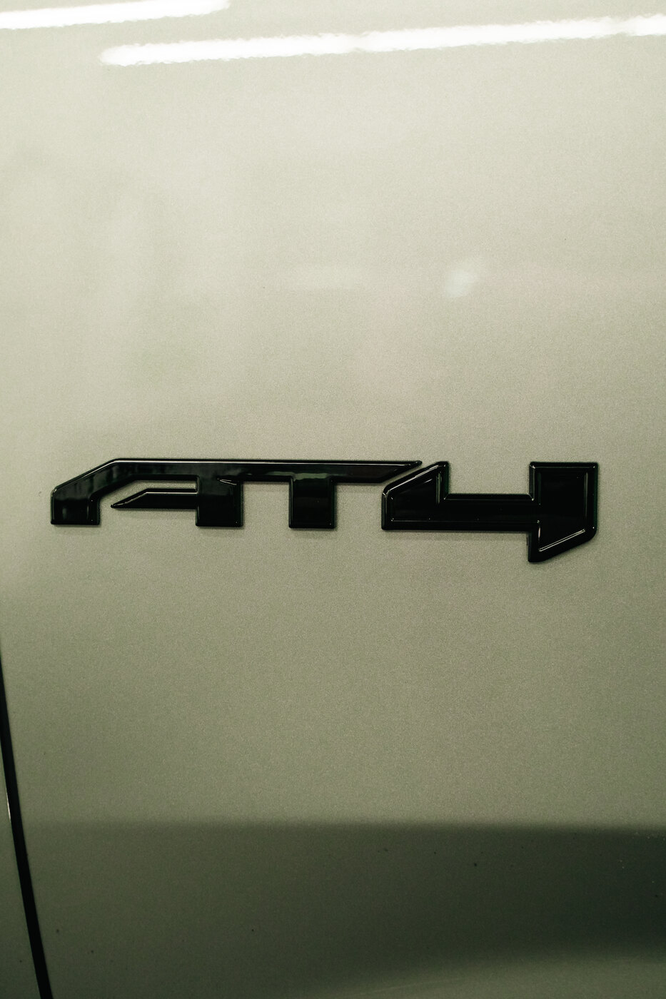 Gloss black AT4 tailgate badge on a 2025 GMC Yukon