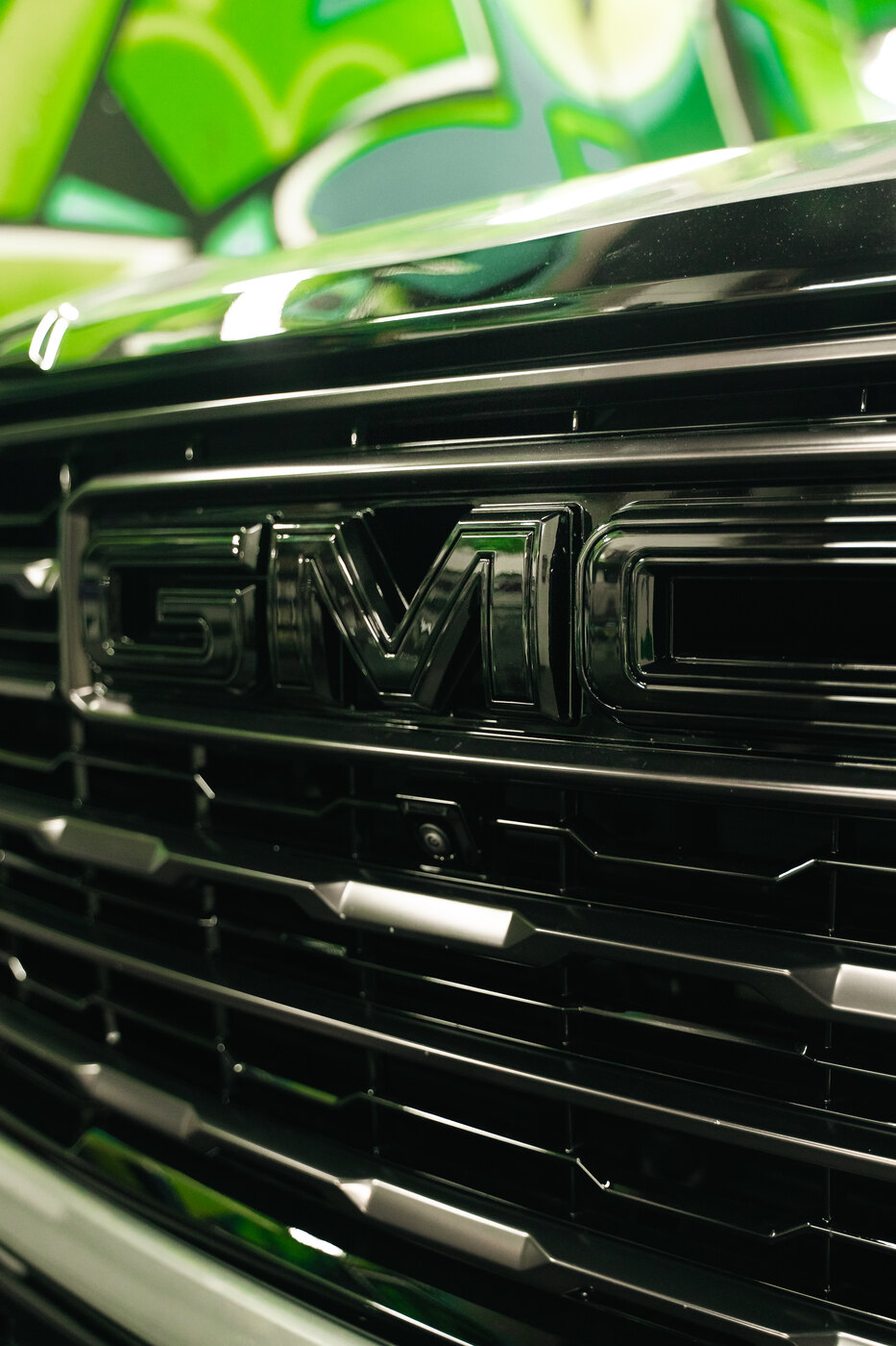 Gloss black GMC grille badge on a blacked out Yukon AT4