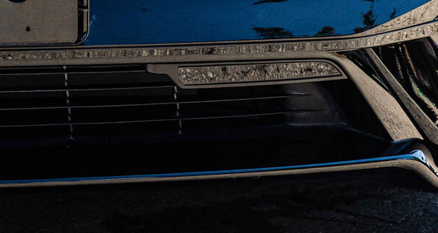 Uniden laser sensor pod set flush into the front bumper of a Tesla Model S Plaid, hidden in plain sight