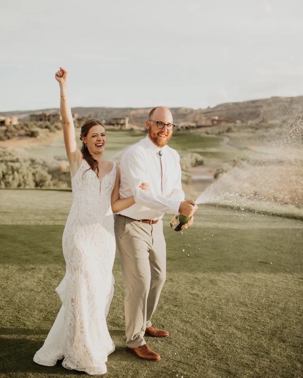 Couple enjoying wedding day with golfers in the background practicing etiquette