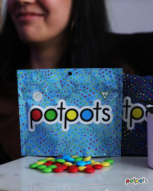 Potpots package with colorful sugar-shelled chocolate edibles scattered on a table