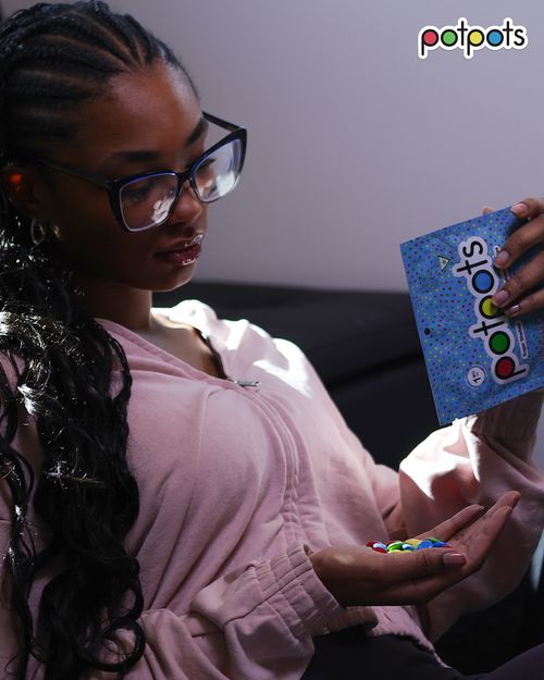 Woman relaxing on couch pouring potpots edibles from the bag into her hand