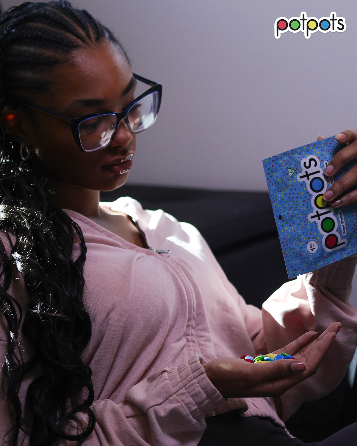 Woman relaxing on couch pouring potpots edibles from the bag into her hand