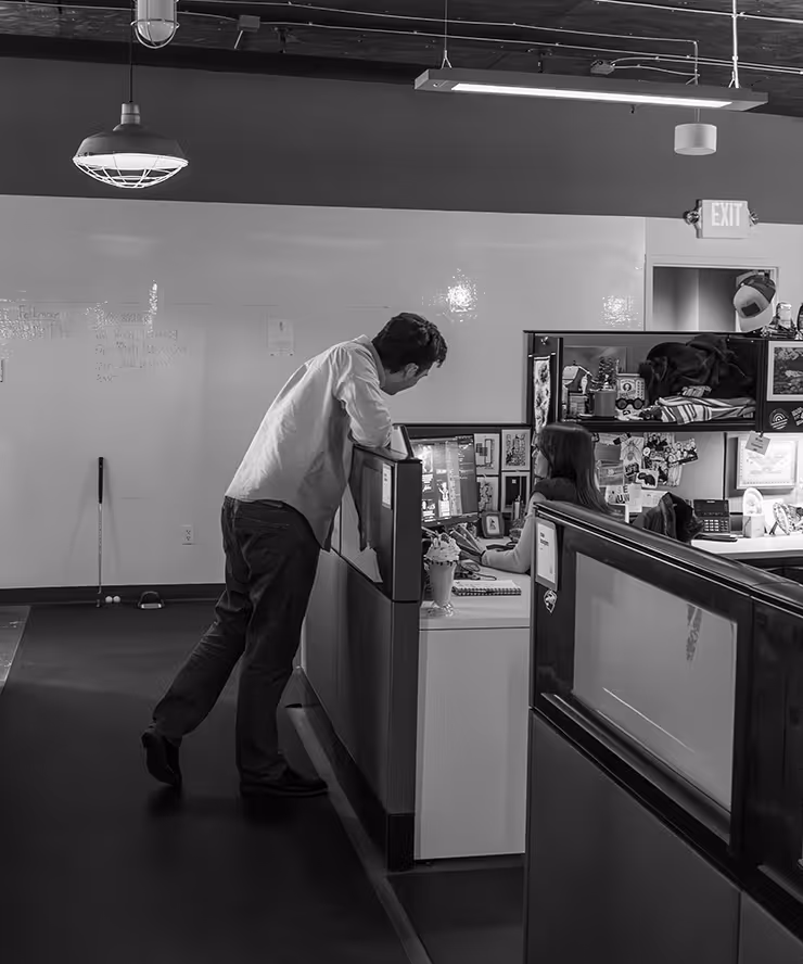 man standing at cubicle to talk to employee