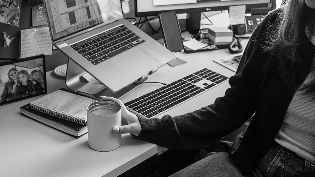 woman holding coffee at her desk