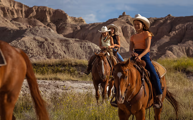 Travel South Dakota - riding horses through the badlands