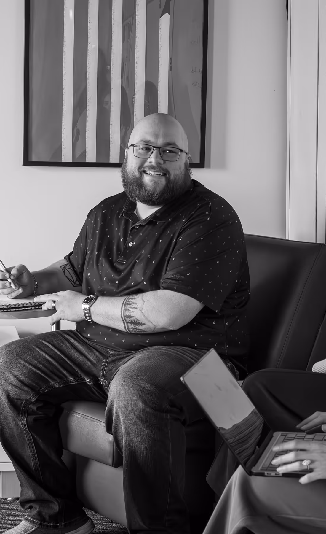 Skylar smiling and listing in a meeting | Lawrence & Schiller