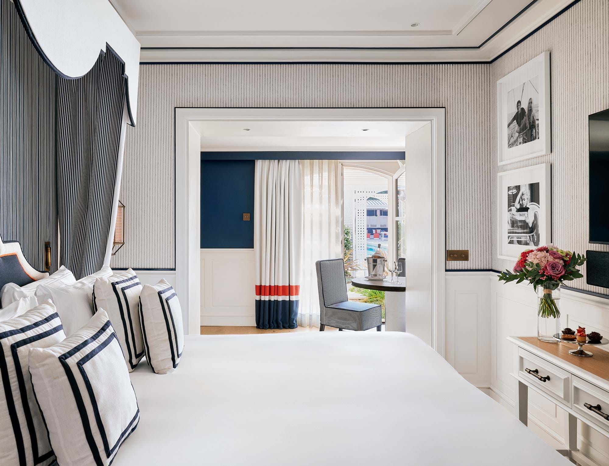 Großzügige Suite im AREV Hotel in Saint-Tropez mit einem großen weißen Bett, schicker minimalistischer Einrichtung und Zugang zu einem hellen Wohnbereich.