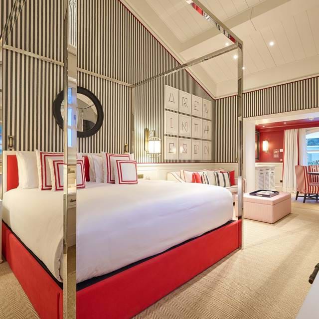 Luxuriöse Suite mit rotem Himmelbett und modernem Dekor im AREV Hotel in Saint-Tropez.