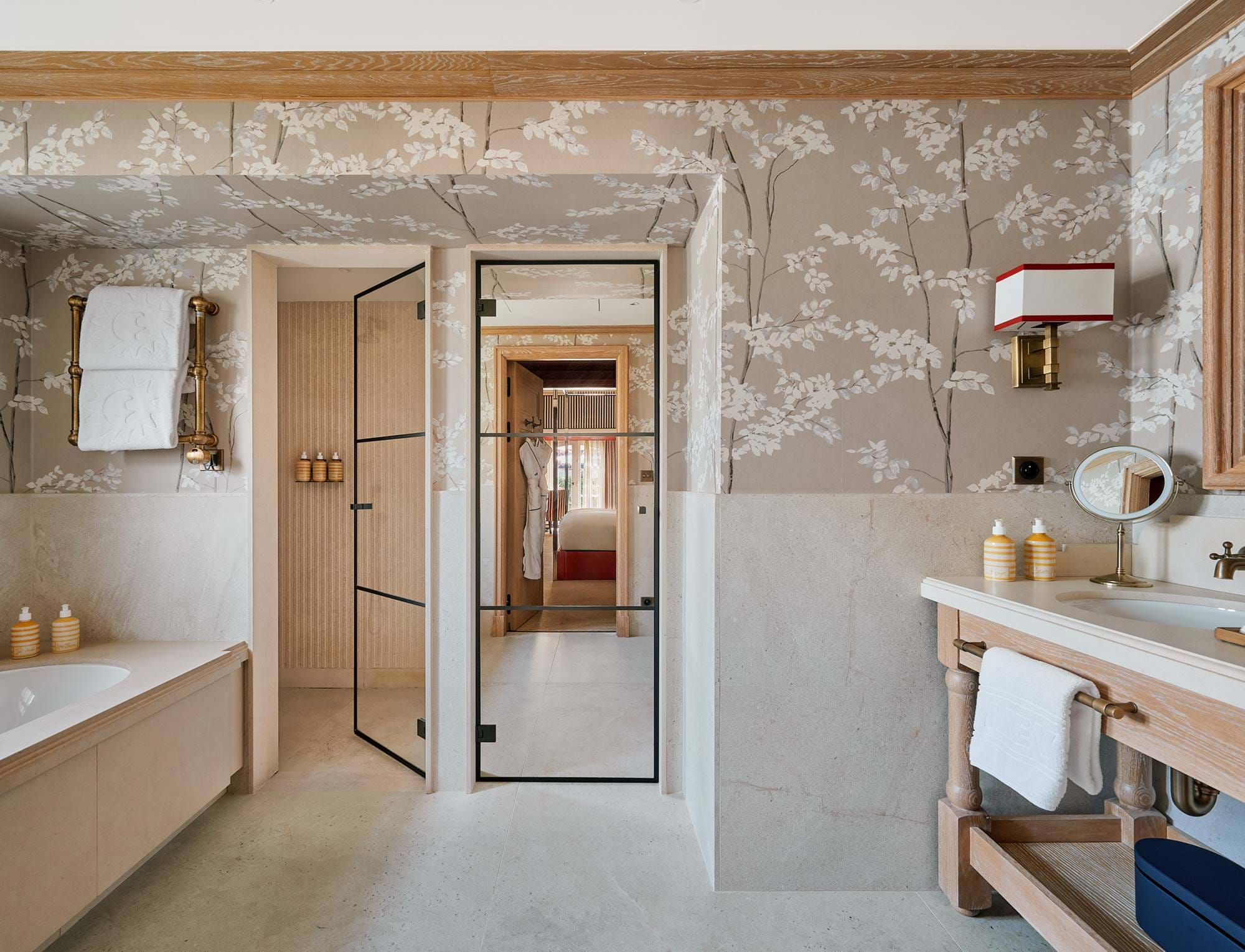 Luxuriöses Badezimmer mit Steinwänden, Badewanne und begehbarer Glasdusche im Hotel AREV in Saint-Tropez.
