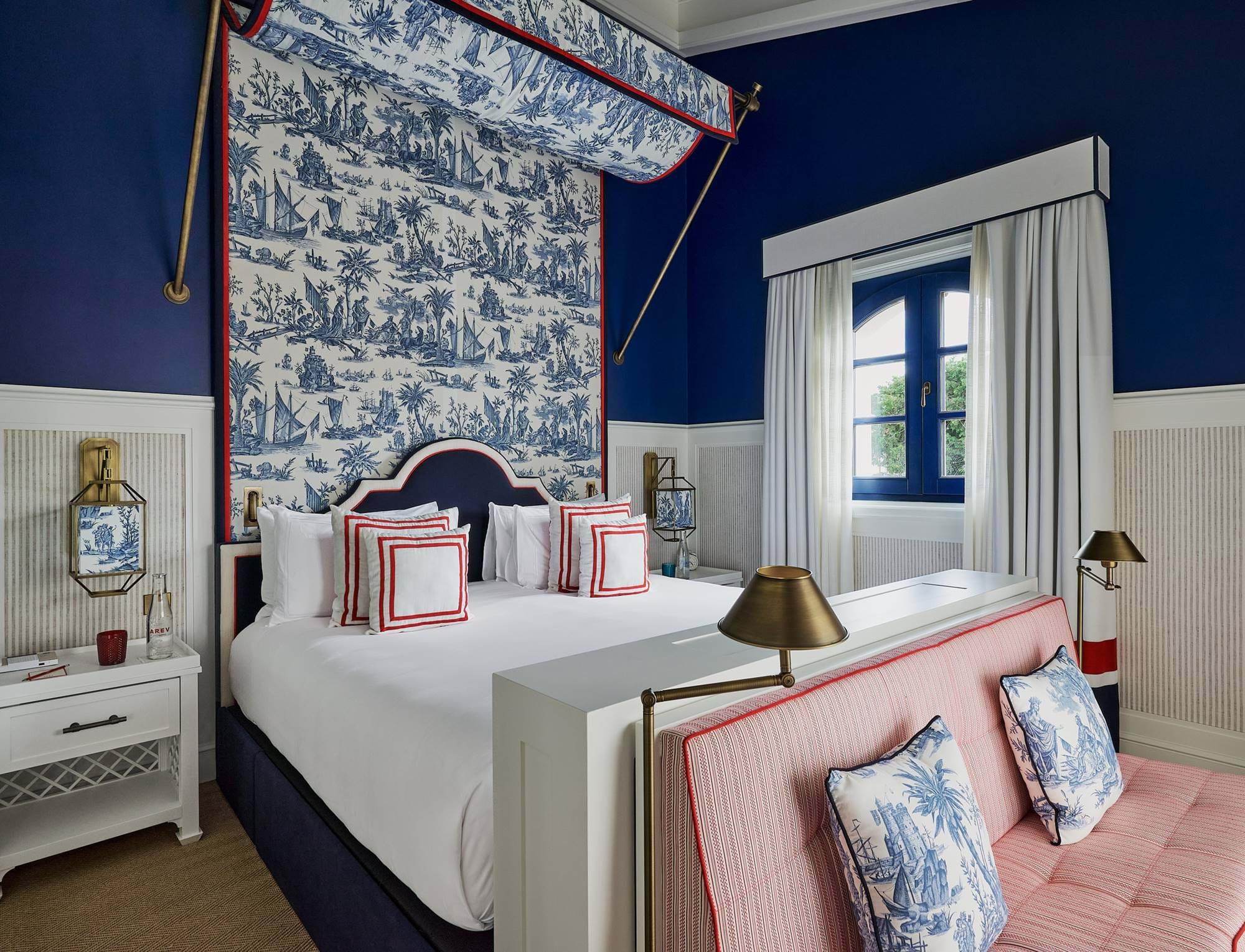Quarto de luxo com dossel estampado e paredes azul-marinho no hotel AREV em Saint-Tropez.