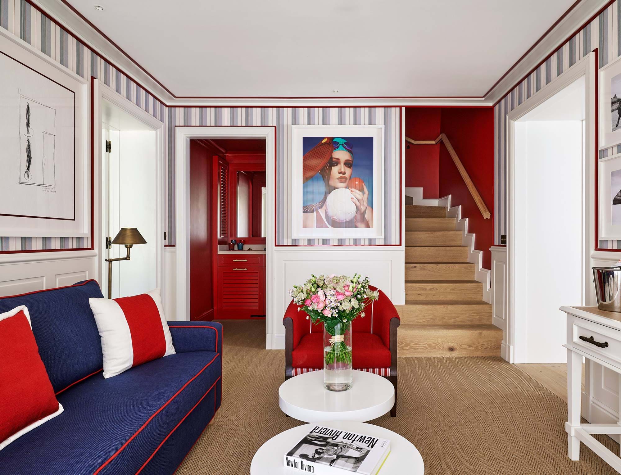 Espaço de estar aberto com escada de madeira, decoração náutica moderna e assentos confortáveis no hotel AREV em Saint-Tropez.