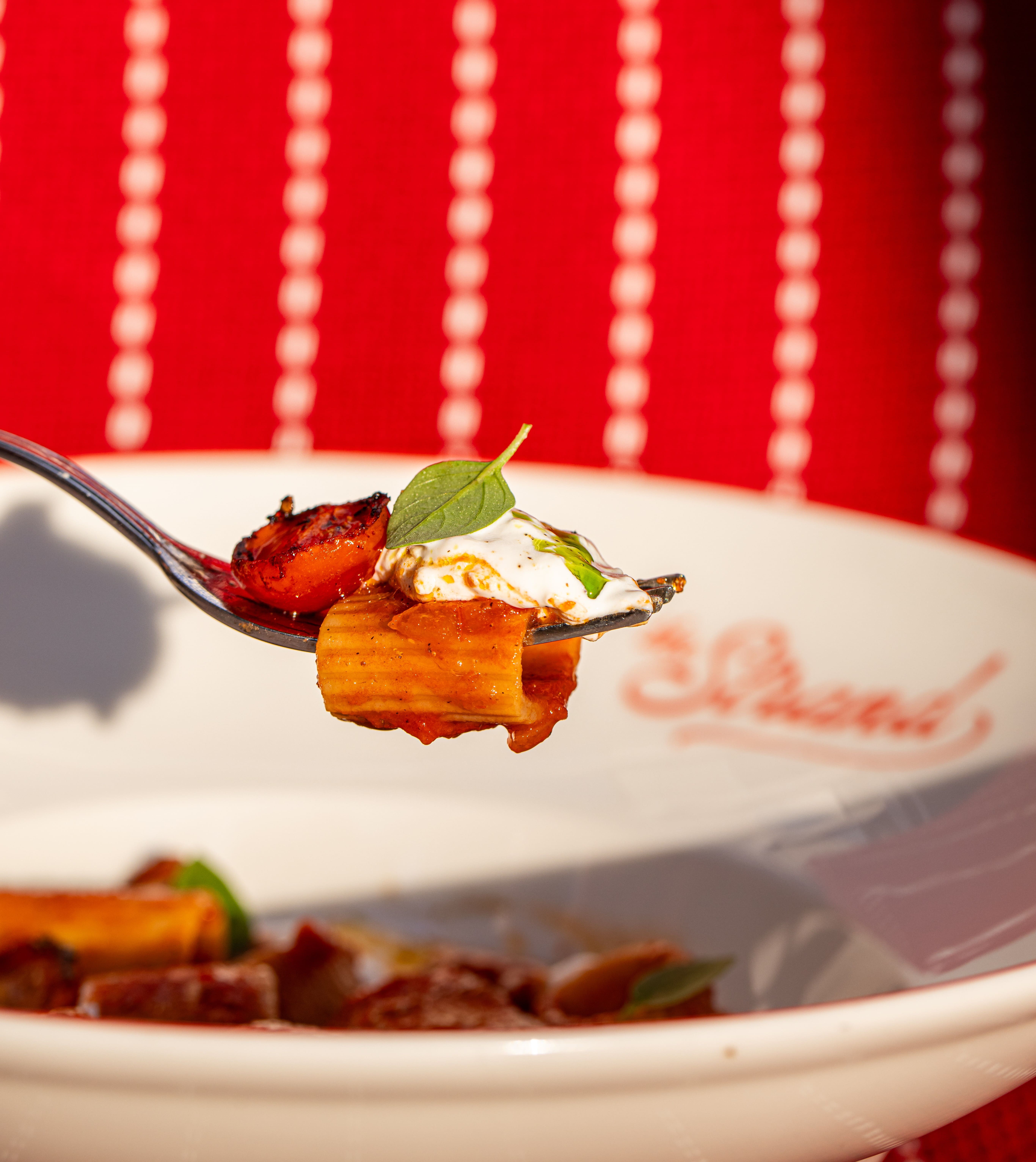 Rigatoni in Tomatensauce mit gerösteter Tomate und Burrata, auf dem Signaturgeschirr des Restaurants The Strand im Hotel Arev Saint-Tropez