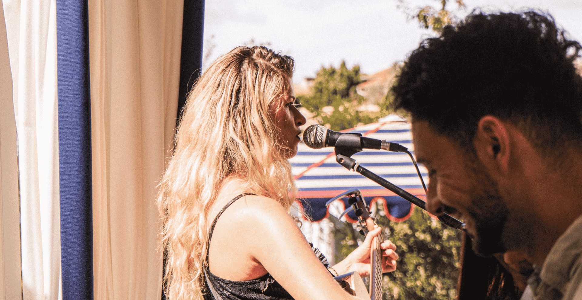 Ein Open-Air-Event mit Live-Musik, bei dem eine Frau singt und Gitarre spielt