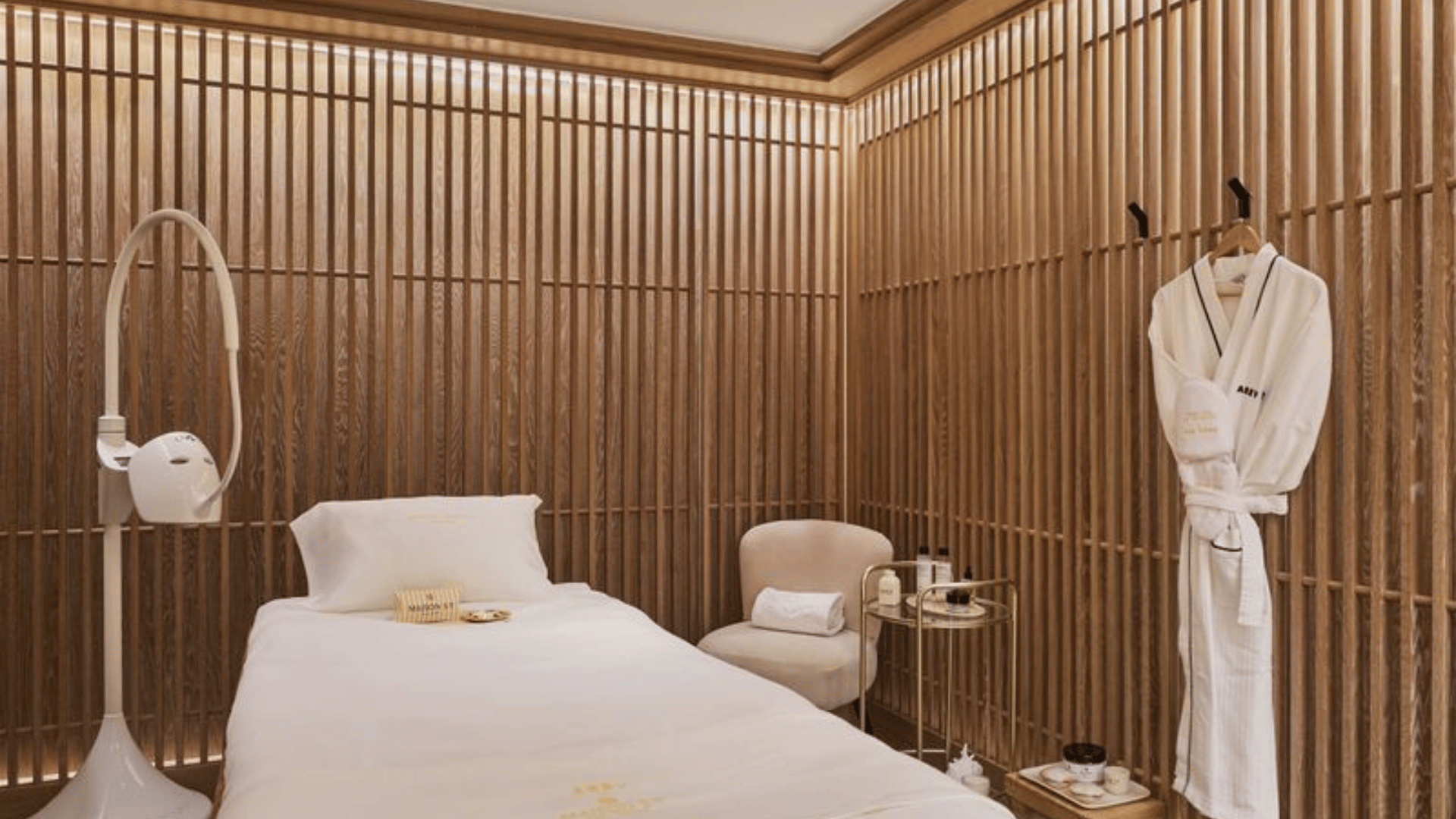 Ein ruhiger Luxus-Spa-Behandlungsraum in Saint-Tropez mit Massageliegen, einer Steinbadewanne und Blick auf das Mittelmeer.