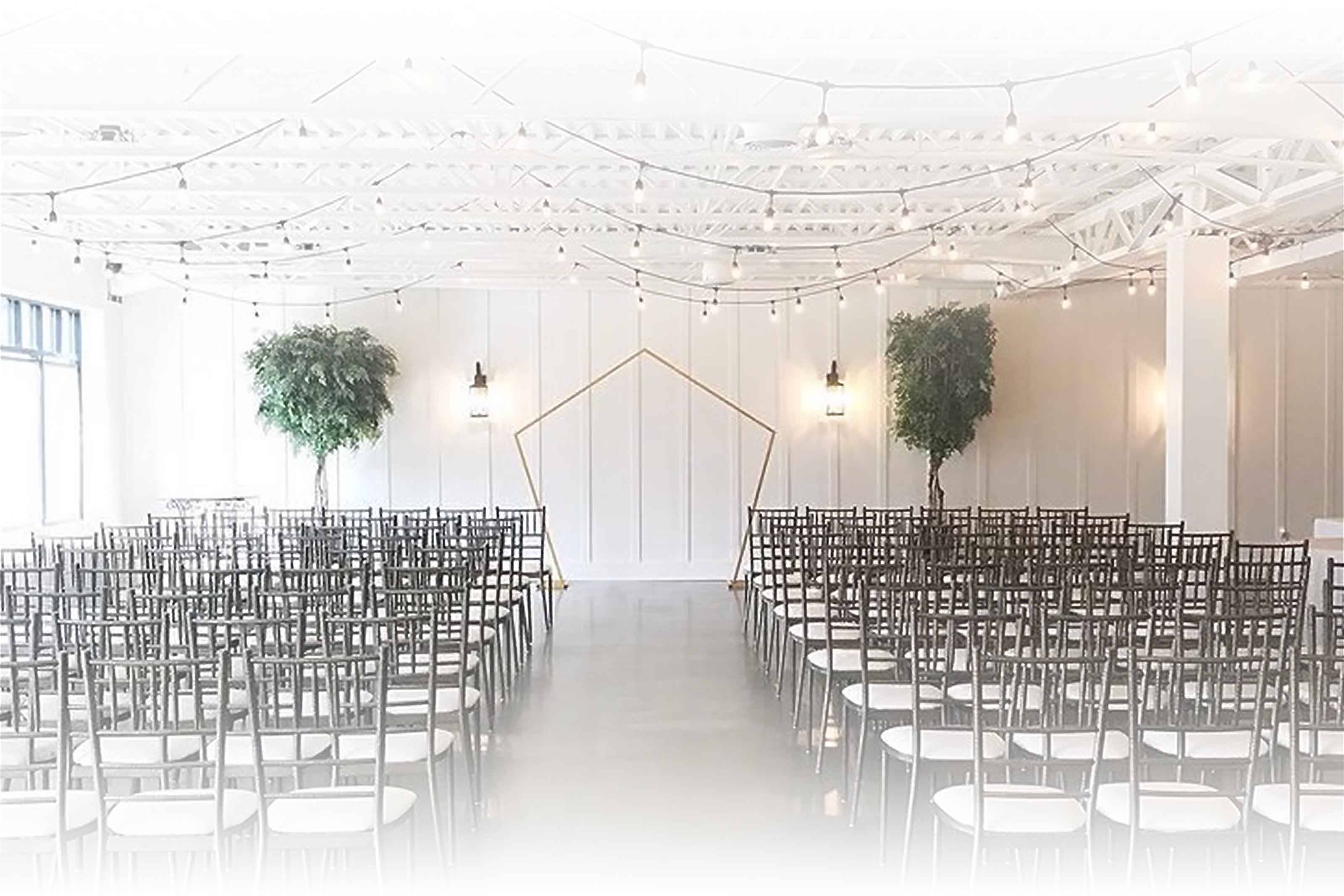 Ceremony setup with rows of chairs facing a minimalist geometric arch at 5th East Hall.