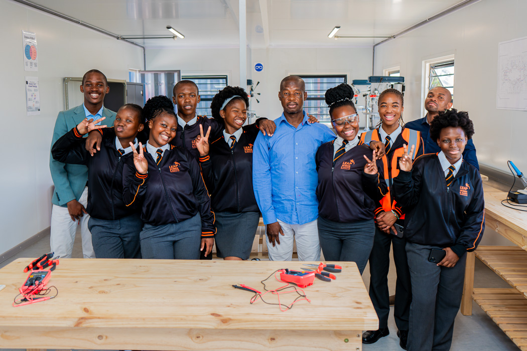 Bustling café with people sitting at tables and shelves stocked with items. The atmosphere is lively and social, with casual conversations.