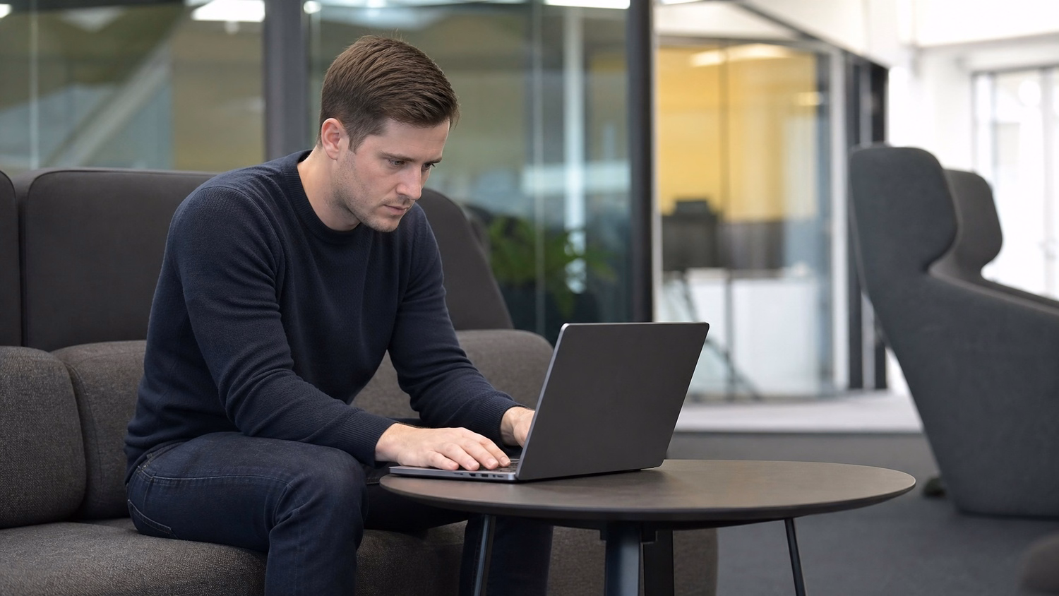 LOUNGE AREA LAPTOP An IT professional one person working on a laptop in a ca