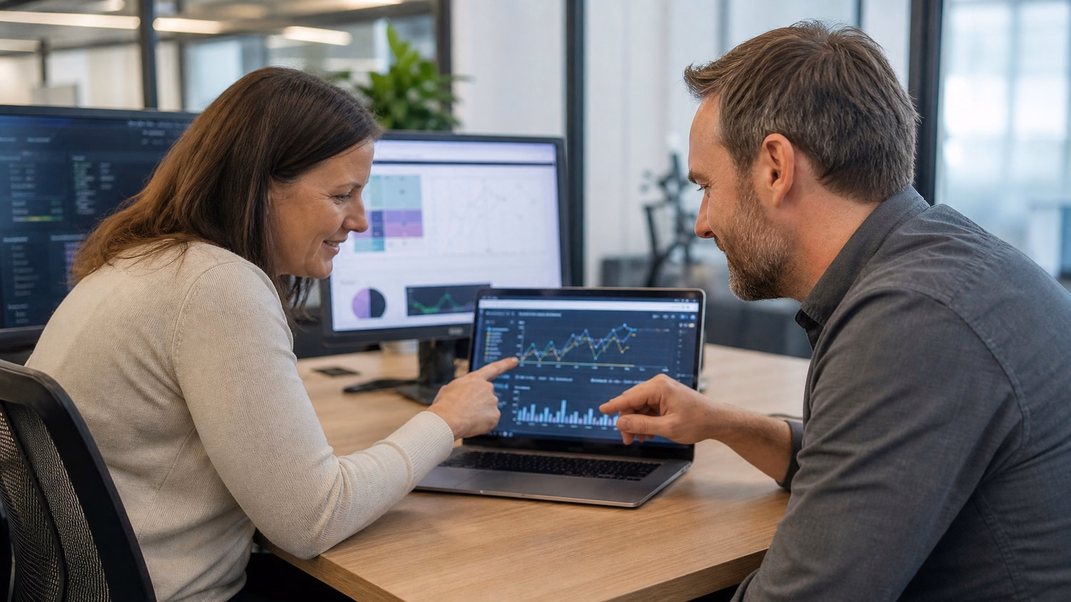 Team discussing complex business intelligence graph on laptop