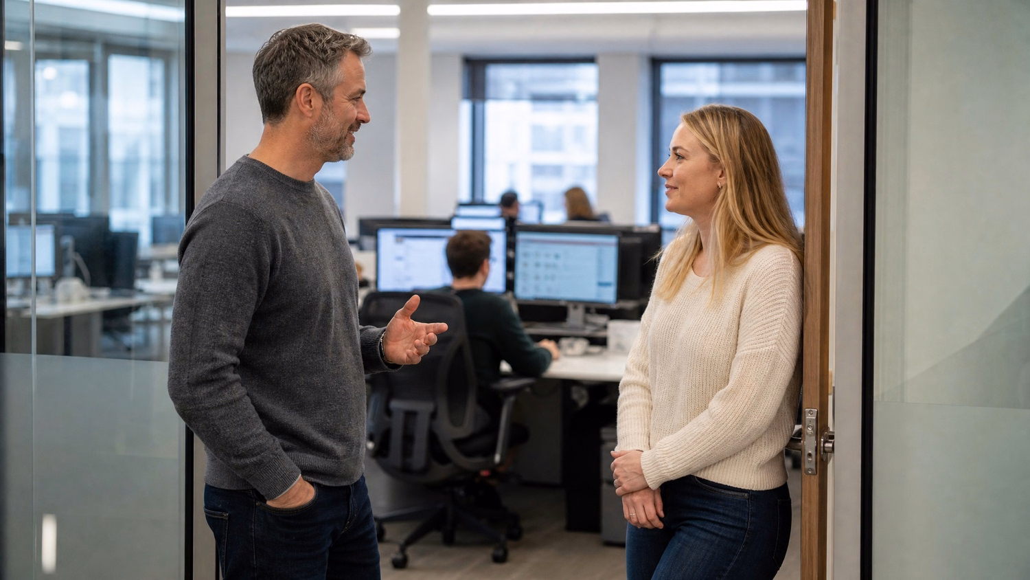 Manager, employee discussing IT infrastructure in doorway 70