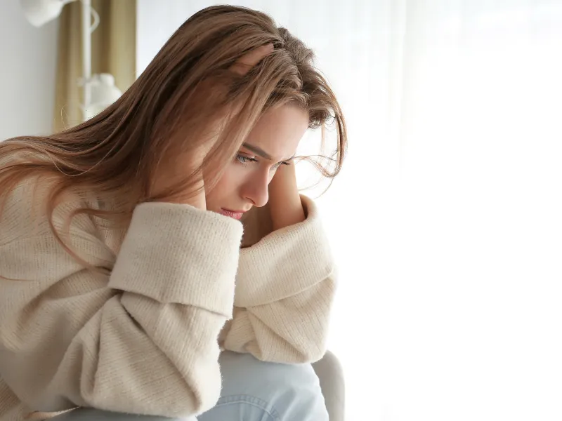 A women holding her head.