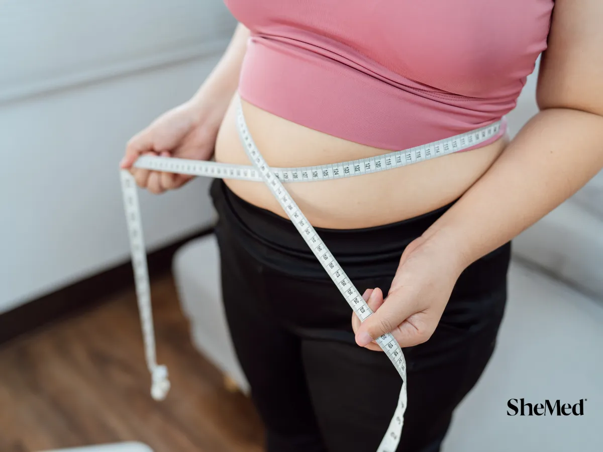 A women measuring her waist.