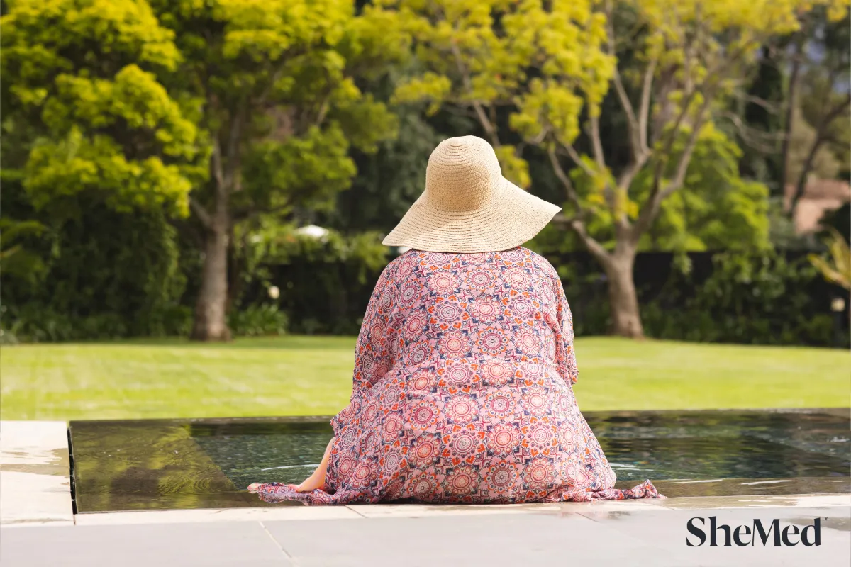 A women sitting with her legs in the pool.