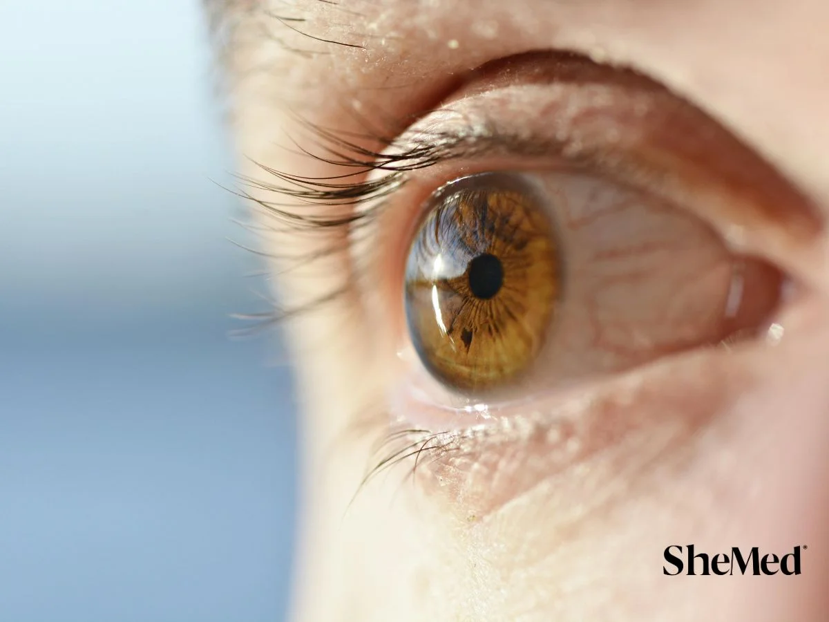 Close-up of amber-colored eye with dark pupils, long eyelashes, and clear iris detail.