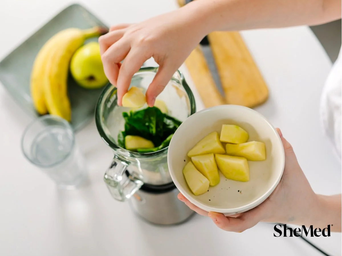 Women adding ingredients in the blender.