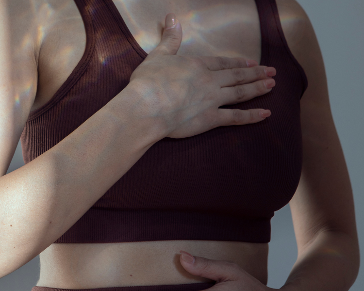 Women holding her chest and stomach in discomfort