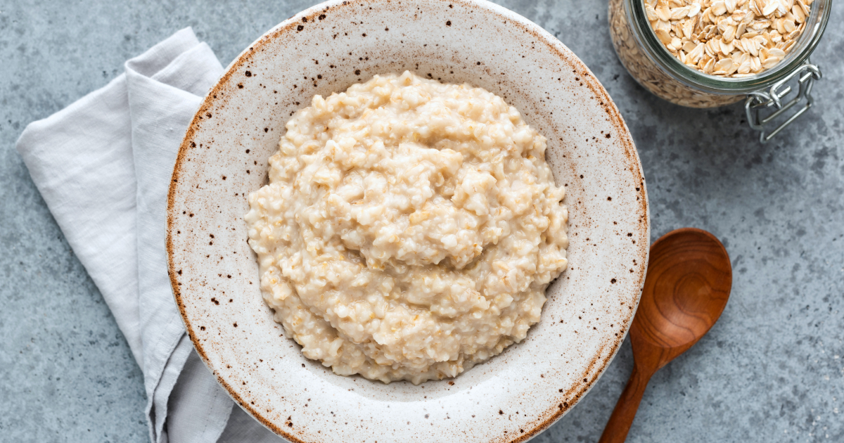 Bowl of healthy porridge with toppings on a light background