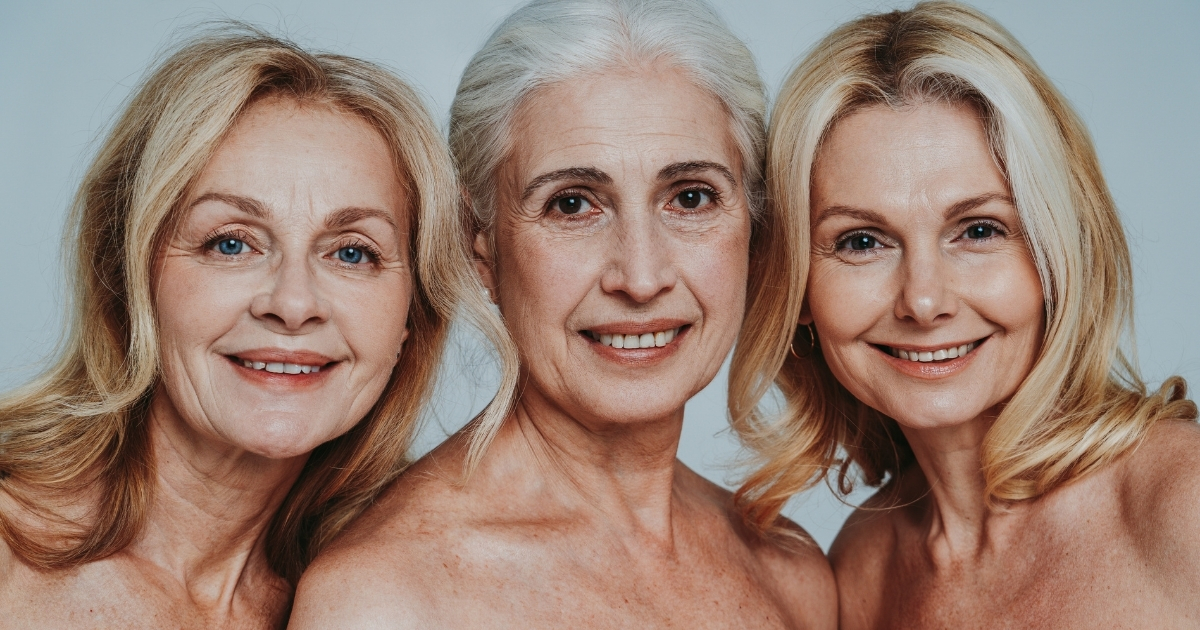 Three women in their fifties smiling confidently together