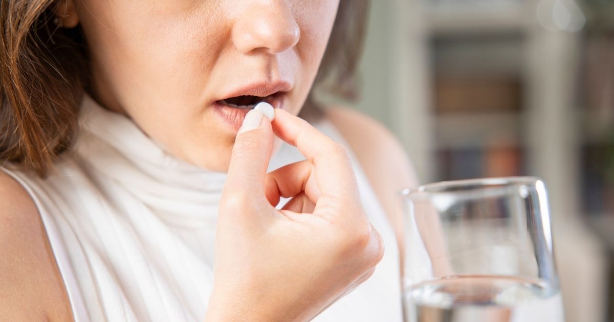 Woman holding a glass of water about to take a Wegovy pill, illustrating what to do after a missed dose