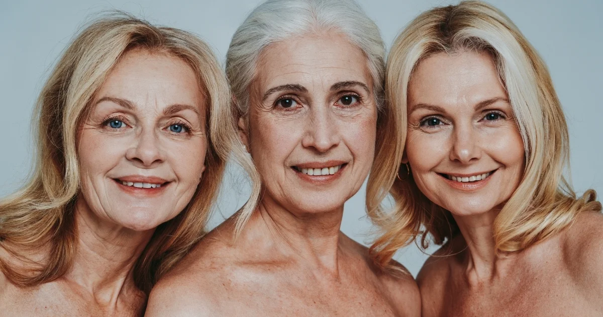 Three women in their fifties smiling confidently together