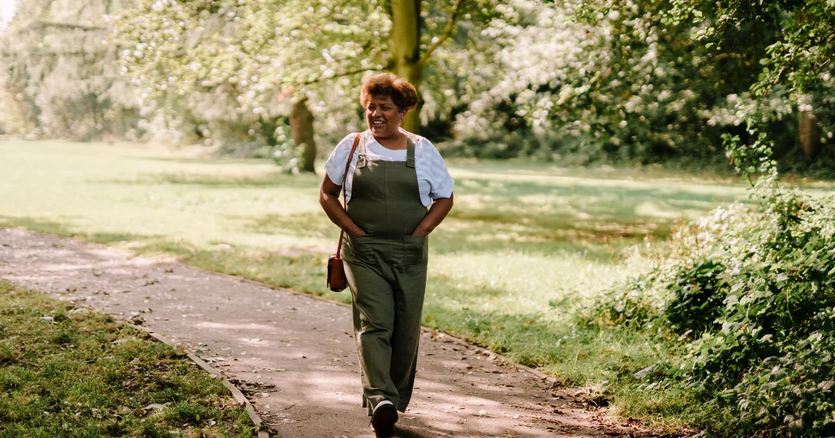 women walking through a park in summer confidently on her GLP-1 medication