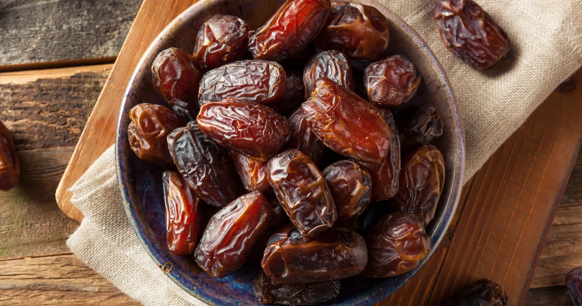 Bowl of Medjool dates on a wooden surface