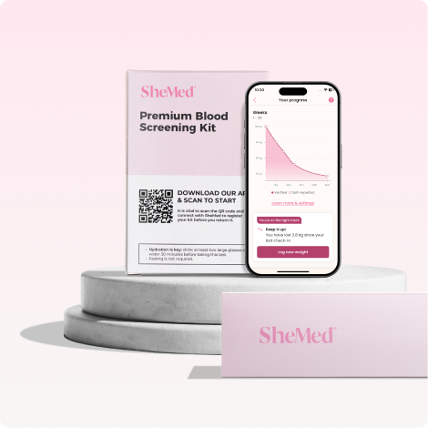 SheMed Premium Blood Screening Kit box alongside a smartphone displaying a health progress chart and weight management messages.