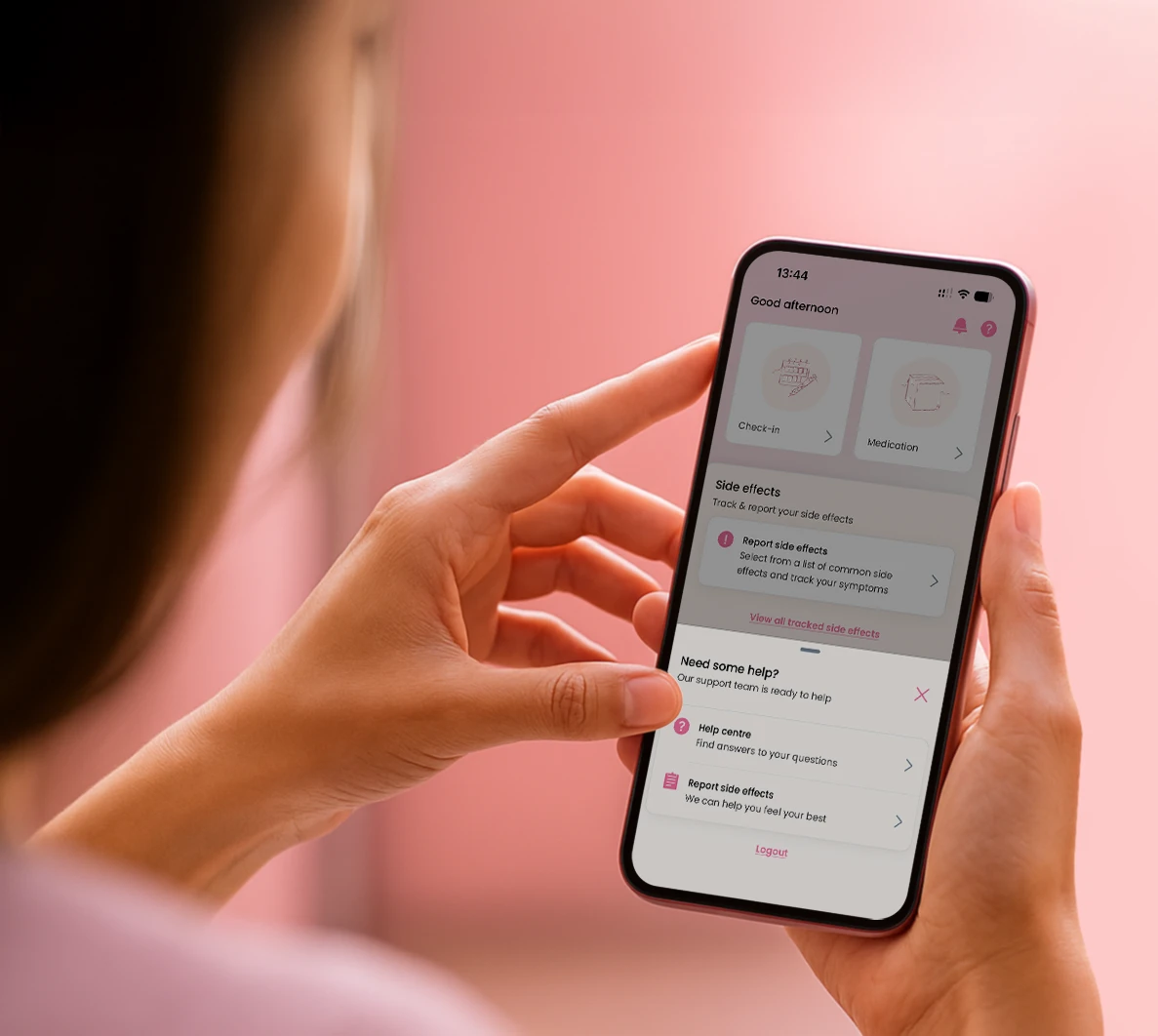 Person holding a smartphone displaying a health app interface with options to check-in, report side effects, access medication info, and get help.