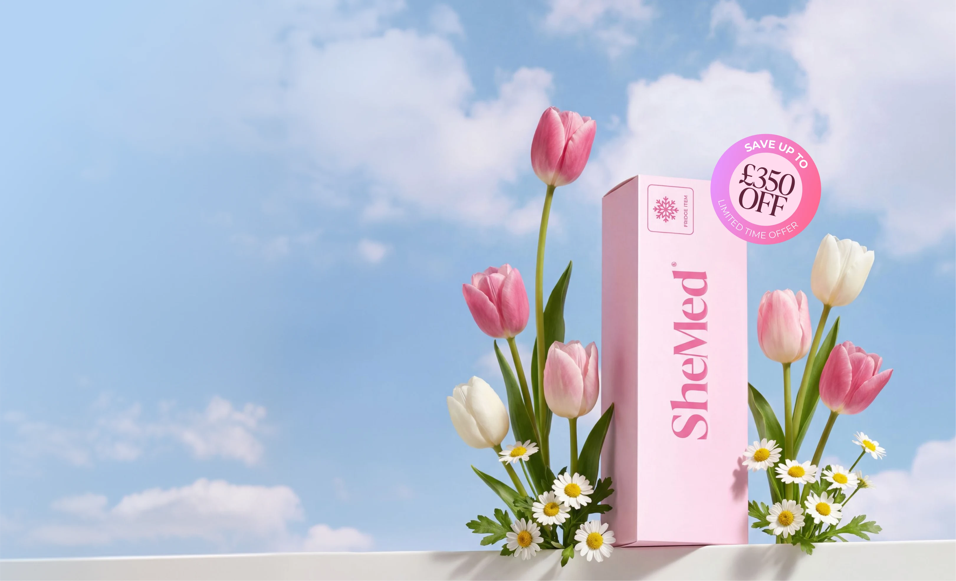 Pink SheMed product box surrounded by pink and white tulips and daisies against a blue sky with clouds.